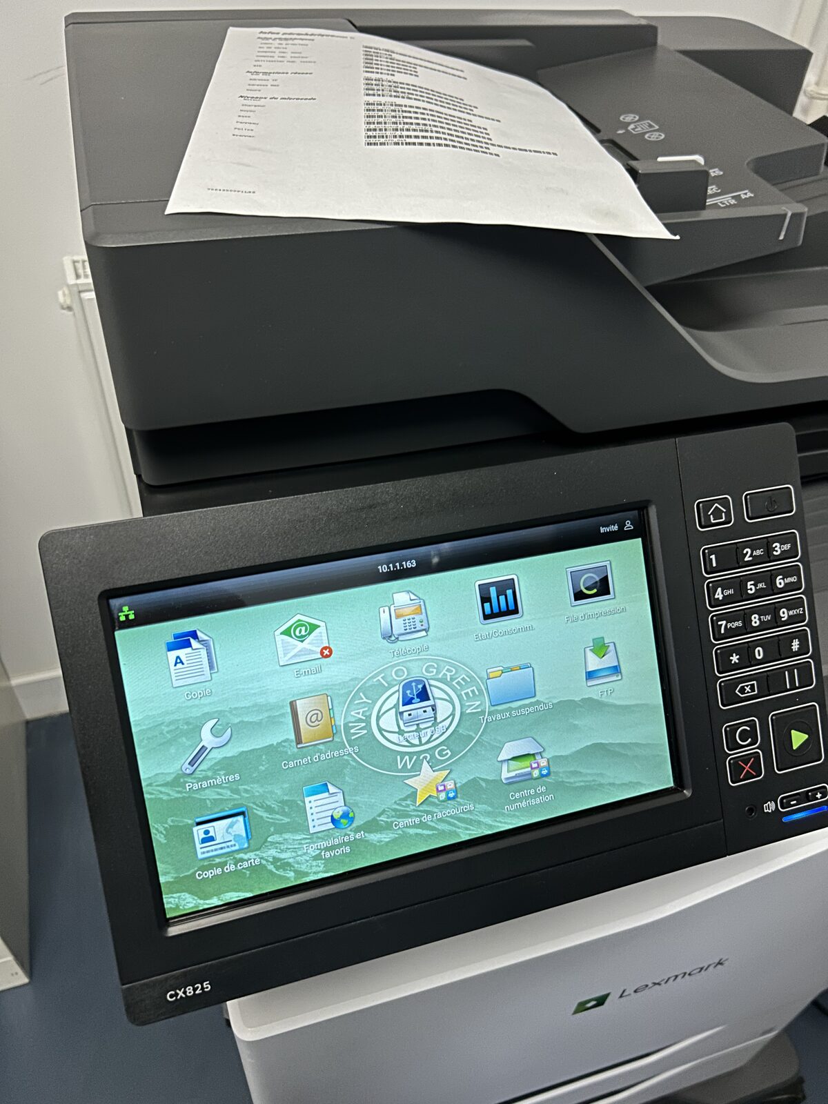 Écran tactile d'un copieur Lexmark CX825 reconditionné, personnalisé avec le fond d'écran Way to Green